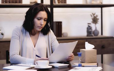 stock-photo-depressed-woman-sitting-table-looking-documents-home stock-photo-depressed-woman-sitting-table-looking-documents-home